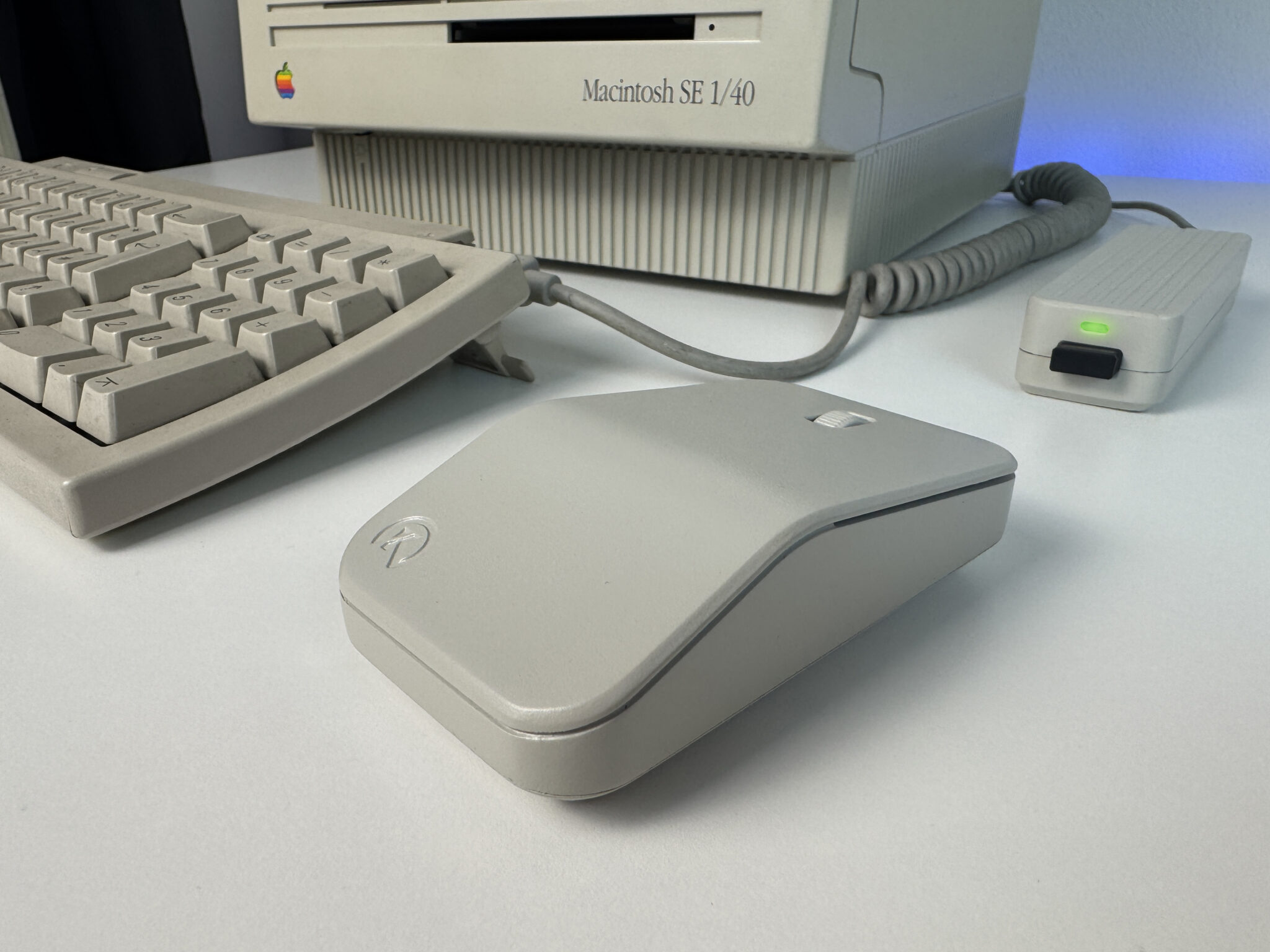 The Retromouse on a desk next to a Macintosh SE