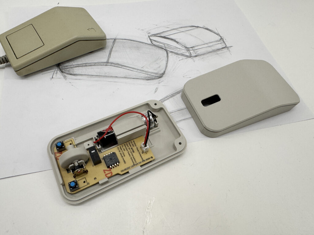 The Retromouse opened up, showing the board and battery